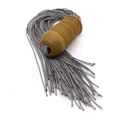 A handmade flogger on a plain background